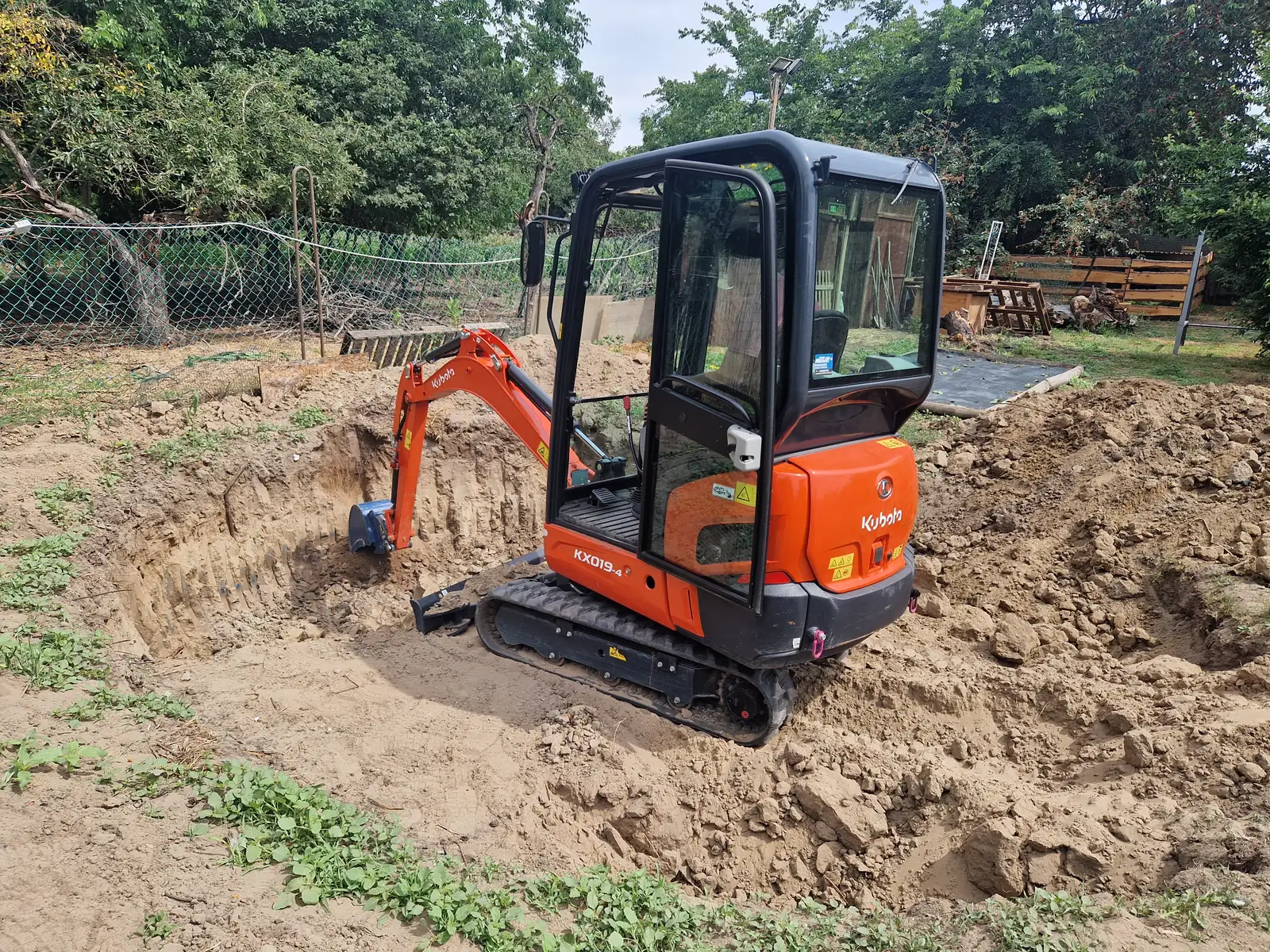 Kubota KX019-4 minikotró — A géppark igáslova: elfér a kertben, mégis elbírja a komolyabb kiemelést is. Kész kertbe, szűk telekre ezt visszük.
